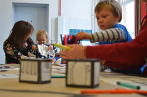 Toddlers and their parents doing arts activities with silver foil and felt tip pens