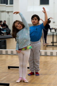 Two children stretching in ballet poses