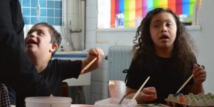Picture of two children sitting at a table in Z-arts gallery workspace doing arts and crafts at Z-access Family Fun Day.