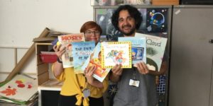 Photo of Z-arts development manager Gemma, and Finance and Administration Officer Ramsey holding children's books donated from Amazon Wishlist