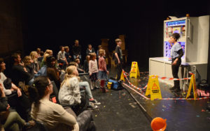 Astonishing Vacuum Cleaner Adventure production photo. A lady next to a pretend catalytic converter with young people and families going up to talk to her.