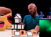Collage of three production images from 'a square world'. 1st image, 1 spherical yellow sponge with a mouth shape and two yellow cube sponges with a mouth shape. Middle photo, man with blue tshirt and beard performing with the sponges. 3rd photo, zoomed out photo of the set showing that the performance is happening on a glowing green desk