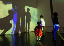 Photo of children dancing in front of wall projections
