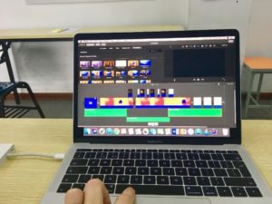 Photo of a macbook on a desk with graphic design software on the screen