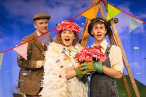 Photo of three people in theatrical costume - one is a scarecrow, one is dressed in a white fluffy dress and one is dressed in tweed with a flat cap