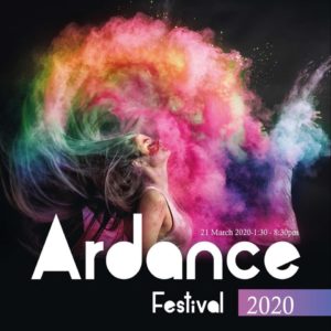 Photo of a young woman pictures in profile flipping her hair back, there is a multicoloured cloud of powder paint billowing out around her