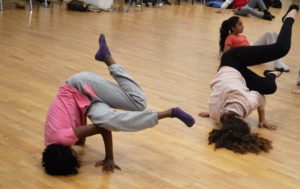Promo image for Z-Dance. Photo of two teenage girls break dancing in a dance studio