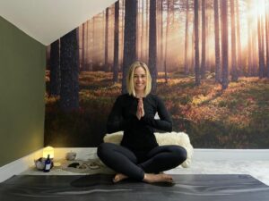 Image of Charlotte, cross-legged on yoga mat
