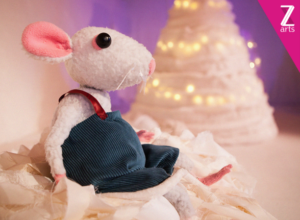 White mouse puppet sitting on a snowy hill