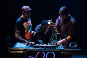 Two puppeteers and a beatboxer with a glow in the dark puppet figure